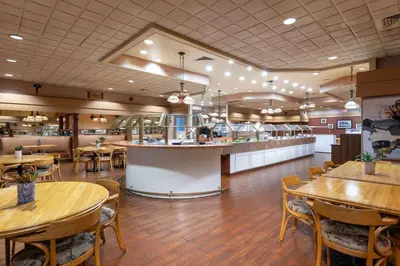 a restaurant with tables and chairs and a bar at Ramada by Wyndham Kissimmee Gateway - Free Theme Park Shuttle in Orlando