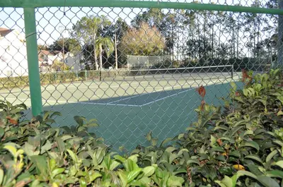 a tennis court behind a chain link fence at Villas at Laguna Bay in Kissimmee