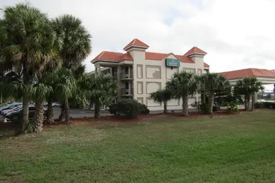 a building with palm trees in front of it at Quality Inn & Suites Kissimmee near Main Gate in Orlando