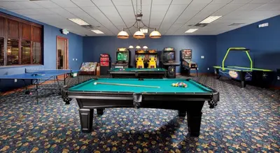 a room with two pool tables and arcade games at Family 4-Bedroom Pool Home Near Disney World in Kissimmee