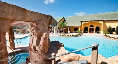 a swimming pool in a resort with a building at Family 4-Bedroom Pool Home Near Disney World in Kissimmee