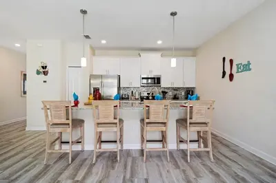 a kitchen with white cabinets and a table and chairs at Four Bedrooms Home with Pool 3079 in Kissimmee