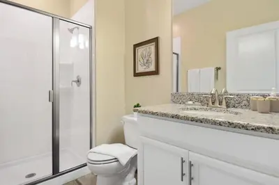 a white bathroom with a toilet and a shower at Four Bedrooms Home with Pool 3079 in Kissimmee