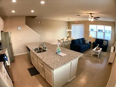 a kitchen and living room with a sink and a counter at Four Bedrooms Townhome 5126 in Kissimmee