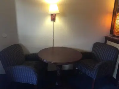 a room with two chairs and a table and a lamp at Maple Leaf Inn & Suites in Kissimmee