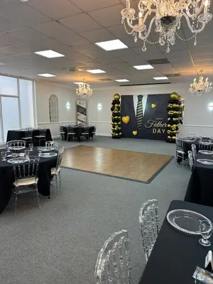 a ballroom with black tables and chairs and a dance floor at Days Inn by Wyndham Orlando Airport Florida Mall in Orlando
