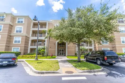 a apartment building with cars parked in a parking lot at Viz Cay 4816 in Orlando