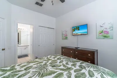 a bedroom with a bed and a tv on a wall at 7741 Windsor Hills in Orlando