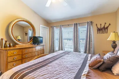 a bedroom with a bed with a mirror and a dresser at 7669 Windsor Hills in Orlando