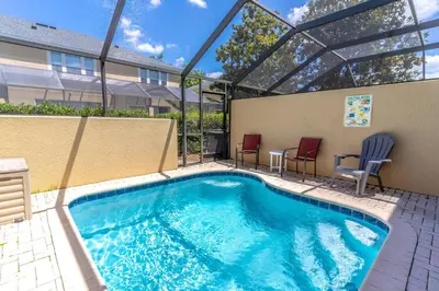a swimming pool with two chairs and a table at 7669 Windsor Hills in Orlando