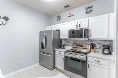 a kitchen with stainless steel appliances and white cabinets at 3031 Encantada in Kissimmee
