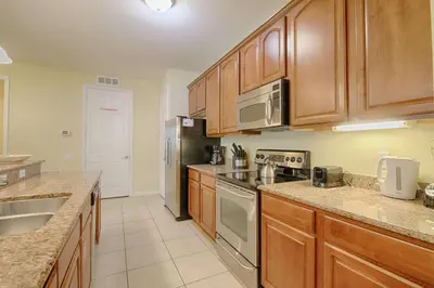 a kitchen with wooden cabinets and stainless steel appliances at 5036 105 Viz Cay in Orlando