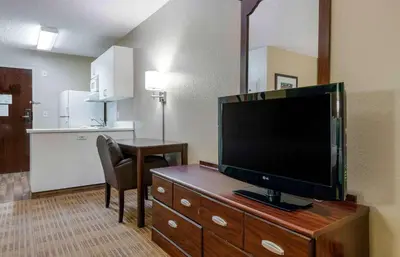 a living room with a flat screen tv on a dresser at Extended Stay America Select Suites - Orlando - Conven Ctr - Sports Complex in Orlando