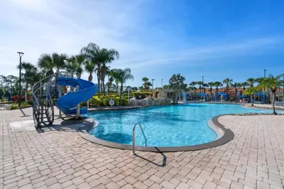 a swimming pool at a resort with a slide at 8960 Paradise Palms in Kissimmee