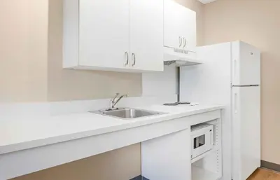 a white kitchen with a sink and a microwave at Extended Stay America Suites - Orlando - Lake Buena Vista in Orlando