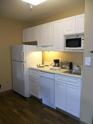 a kitchen with white cabinets and a white refrigerator at Extended Stay America Suites - Orlando - Lake Buena Vista in Orlando