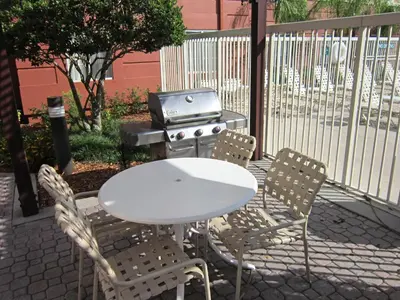 a white table and chairs with a barbecue grill at Extended Stay America Suites - Orlando - Lake Buena Vista in Orlando
