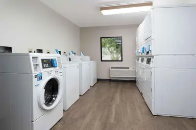 a laundry room with white washers and dryers at Extended Stay America Suites - Orlando - Lake Buena Vista in Orlando