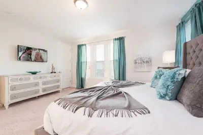 a bedroom with a large bed and a dresser at Groovy Mouse House with private pool in Orlando