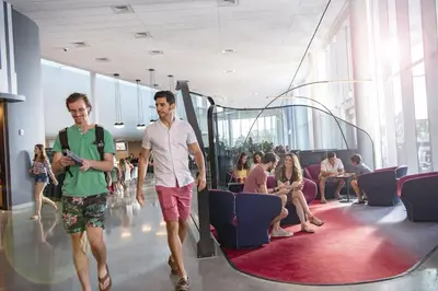 two men walking through a lobby with people sitting at Universal's Aventura Hotel in Orlando