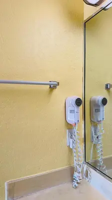 a bathroom with two hair dryers and a mirror at Budget Inn Of Orlando in Orlando