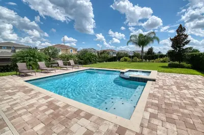 a swimming pool with chairs in a yard at Exquisite Home With Media Room & Games With Waterpark & Resort Access Near Disney At Encore Resort- 7600Mc in Kissimmee
