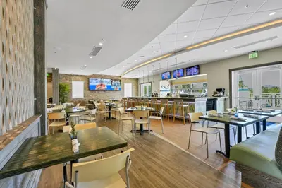 a restaurant with tables and chairs and a bar at Luxury Home Near Disney With Private Pool, Waterpark & Resort Access At Encore Resorts Reunion - 211Mn in Kissimmee