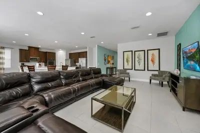 a living room with a leather couch and a television at Vibrant Elite Home With Private Pool, Theater Room And Waterpark & Resort Access Near Disney At Encore Resort - 7605Mc in Kissimmee