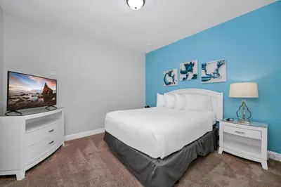 a bedroom with a white bed and a tv at Vibrant Elite Home With Private Pool, Theater Room And Waterpark & Resort Access Near Disney At Encore Resort - 7605Mc in Kissimmee
