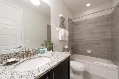 a bathroom with a sink and a toilet and a tub at Modern Home Near Disney With Private Pool, Media Room And Waterpark & Resort Access At Encore Resorts Reunion - 7576Mr in Kissimmee