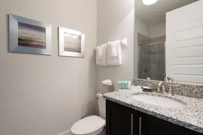 a bathroom with a sink and a toilet and a mirror at Modern Home Near Disney With Private Pool, Media Room And Waterpark & Resort Access At Encore Resorts Reunion - 7576Mr in Kissimmee
