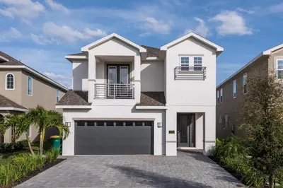 a white house with a garage at Modern Home Near Disney With Private Pool, Media Room And Waterpark & Resort Access At Encore Resorts Reunion - 7576Mr in Kissimmee