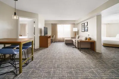 a hotel room with a desk and a living room at Residence Inn Orlando Lake Buena Vista in Orlando