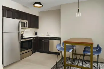 a kitchen with a refrigerator and a table and chairs at Residence Inn Orlando Lake Buena Vista in Orlando