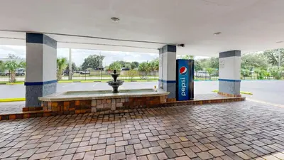 a building with a fountain in the middle of a street at Days Inn by Wyndham Orlando Downtown in Orlando