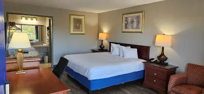 a hotel room with a bed and a chair at Days Inn by Wyndham Orlando Downtown in Orlando