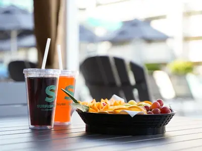 a cup of soda and a bowl of fruit on a table at Holiday Inn Resort Orlando Suites - Waterpark by IHG in Orlando