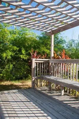 a wooden bench sitting under a wooden pergola at Villas at Fortune Place in Kissimmee