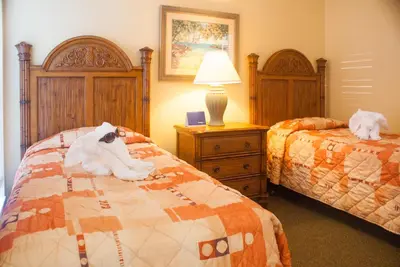 a bedroom with two beds with stuffed animals on them at Villas at Fortune Place in Kissimmee