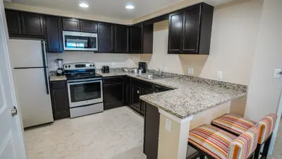 a kitchen with black cabinets and a white refrigerator at Vacation Village Orlando, Celebration in Orlando