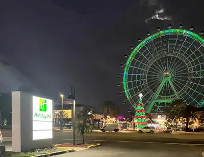 a christmas tree and a ferris wheel at night at Holiday Inn Orlando International Dr-ICON by IHG in Orlando