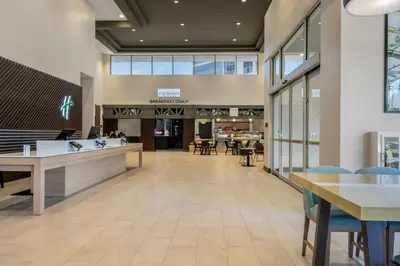 a lobby with tables and chairs in a building at Holiday Inn Orlando International Dr-ICON by IHG in Orlando