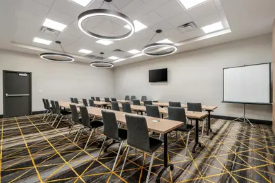 a conference room with tables and chairs and a whiteboard at Holiday Inn Orlando International Dr-ICON by IHG in Orlando