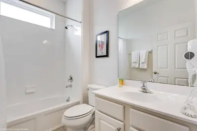 a white bathroom with a toilet and a sink at Veranda Palms 8 Bedroom Home with Pool 1722 in Kissimmee