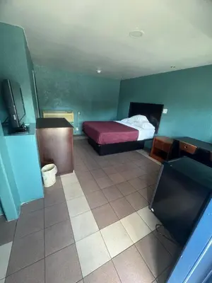 a room with a bed and a tv in it at Budget Motel in Orlando