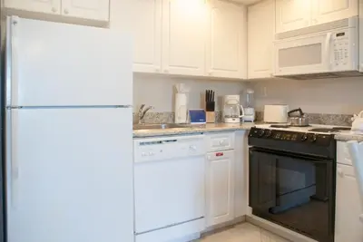 a kitchen with white cabinets and a white refrigerator at Grand Lake & Lifetime of Vacations Resorts in Orlando