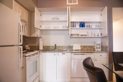 a kitchen with white cabinets and a white refrigerator at Grand Lake & Lifetime of Vacations Resorts in Orlando