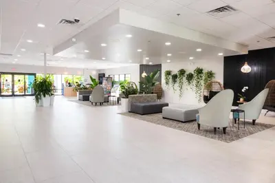 a lobby with chairs and plants in a building at Coco Key Hotel & Water Park Resort in Orlando
