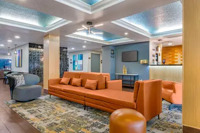 a living room with a couch and a chair at Best Western Plus Universal Inn - Free Shuttle to Universal Studios! in Orlando