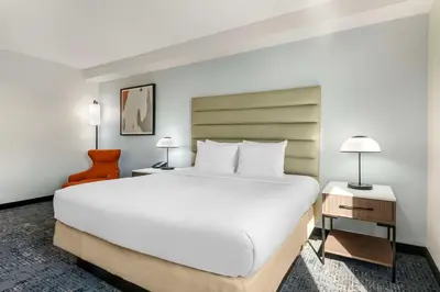 a bedroom with a large white bed and two lamps at Best Western Plus Universal Inn - Free Shuttle to Universal Studios! in Orlando